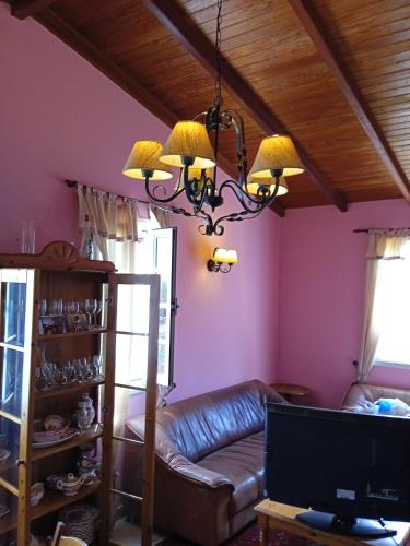 a living room with a leather couch and a chandelier at Mar de flores in Vega de San Mateo
