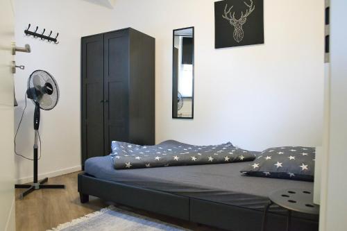 a bedroom with a bed with blue sheets and a fan at Heide Ferienwohnung Süd Nr-2 in Schneverdingen