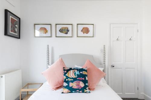 a white bedroom with a bed with pink pillows at Trendy Central 1 Bed Flat with Roof Terrace in Brighton & Hove