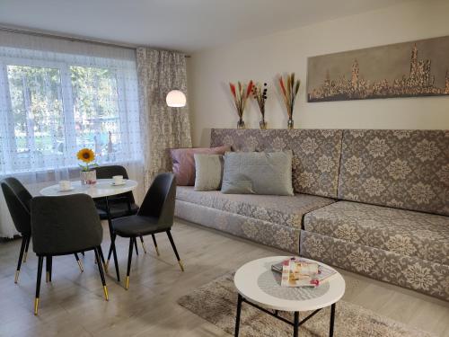 een woonkamer met een bank en een tafel bij Apartment Dalyce in Šiauliai