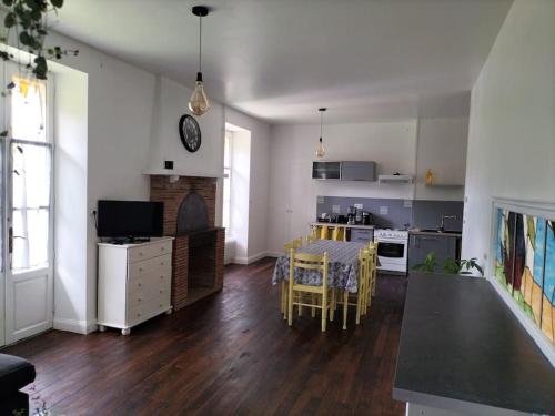 cocina y sala de estar con mesa y sillas en Logement entier pour 6 personnes en Saint-Maixent-lʼÉcole
