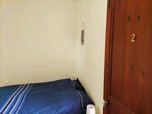 Habitación pequeña con cama y puerta de madera en Logement entier pour 6 personnes en Saint-Maixent-lʼÉcole