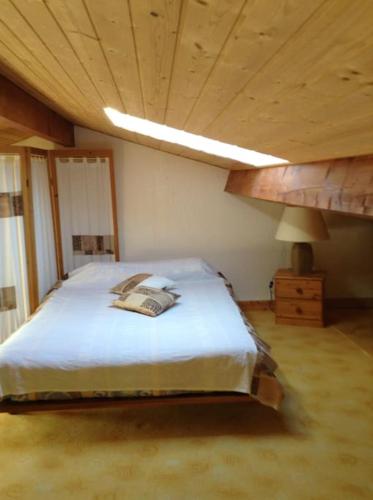 une chambre avec un grand lit avec un plafond en bois dans l'établissement Frontignan: appartement en front de mer avec vue, à Frontignan