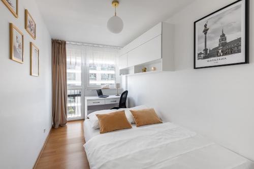 a white bedroom with a bed and a desk at Grzybowska39 Apartments in Warsaw