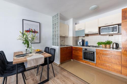 una cucina con armadi in legno e tavolo con sedie di Grzybowska39 Apartments a Varsavia