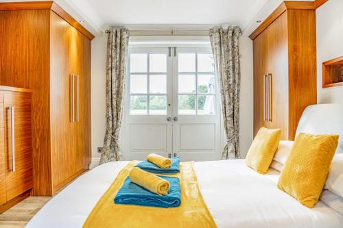 a bedroom with a bed with yellow and blue towels on it at The Paddocks Romantic Retreat in Boston