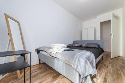 a bedroom with a bed and a mirror in it at Appartement near Disneyland Paris, 2 parking in Torcy