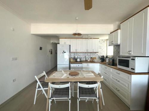 een keuken met een houten tafel en witte apparaten bij Marmaris seaside aparts in Marmaris