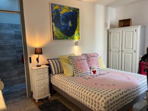 a small bedroom with a bed and a painting on the wall at Appart'hôtel Art Deco in Cannes