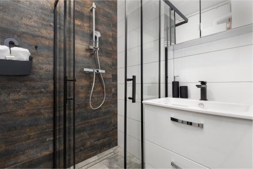 a bathroom with a shower and a sink at Apartament Bursztynowa Przystań in Dziwnówek