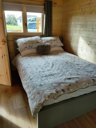 ein Teddybär auf einem Bett in einer Hütte in der Unterkunft ANNES LOG CABIN in Nobber