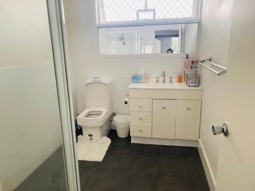 a bathroom with a toilet and a sink and a shower at Comfortable Double room with shared kitchen and bathroom in Perth