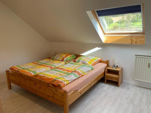 a bedroom with a bed and a window in a attic at Ferienwohnung „Riedforst“ in Melsungen