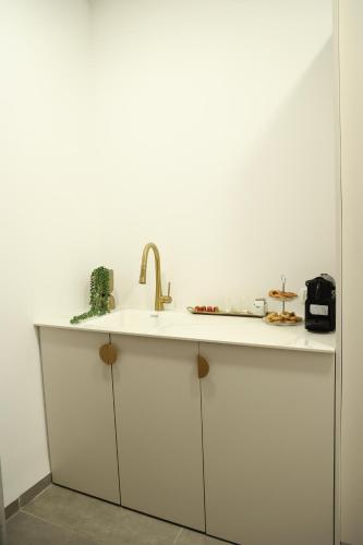 a white kitchen with a sink and a counter at חדרי בוטיק B.Y in Bet Sheʼan