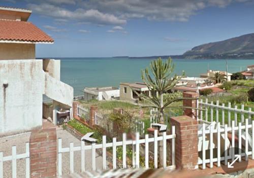 une clôture blanche devant une maison donnant sur l'océan dans l'établissement sizilien, à Trappeto