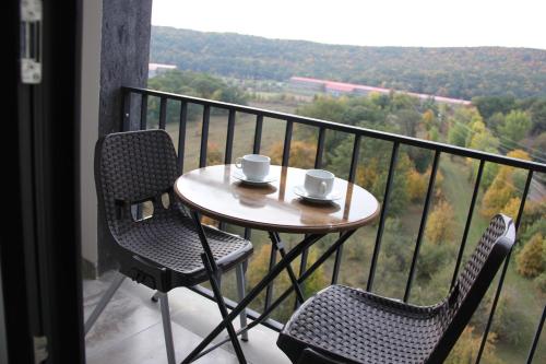 a table and two chairs on a balcony with a view at Цахкадзор кечи аус Уютное студио с видом на лес - Cozy studio with stunning forest views in Tsaghkadzor