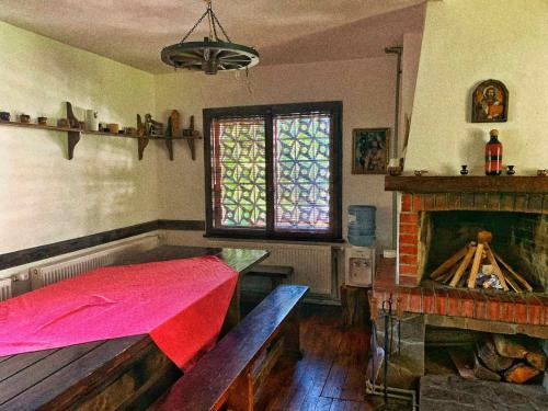 Zimmer mit einem Tisch, einem Kamin und einem Fenster in der Unterkunft Къща за гости Диляна 