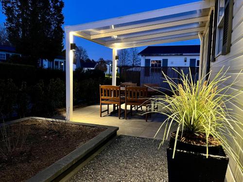 a pergola with a table and chairs on a patio at 30, Holiday Inn Oisterwijk #Hygiëne #Airport Eindhoven #Airco #Bosrijk #Hiking & Biking #Efteling #Safaripark in Oisterwijk