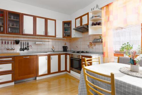a kitchen with wooden cabinets and a table with a tableablish at Entire house with garden near Prague in Benešov