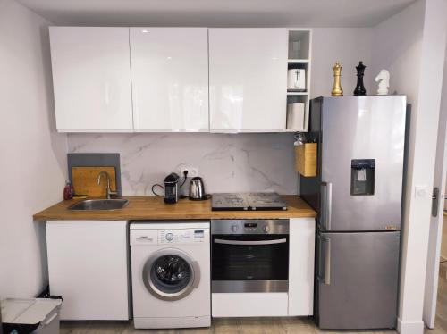 cocina con nevera y lavadora en Lumineux Charming Appartement - Cozy Flat, en Le Chesnay