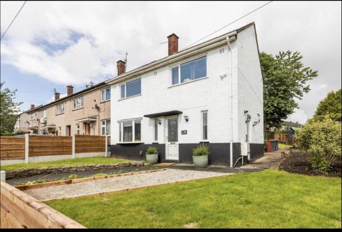 an exterior view of a white house at 3 Bed House - Sleeps 5 - Parking - Garden - Wifi in Blackburn