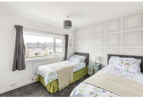 a bedroom with two beds and a window at Come & unwind in Charming 5 Bed House in Blackburn in Blackburn