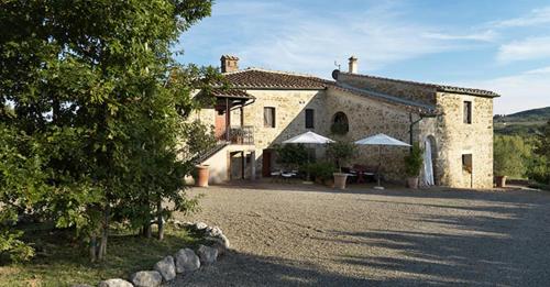 a large stone building with a driveway in front of it at Agriturismo Piettorri in Casole dʼElsa