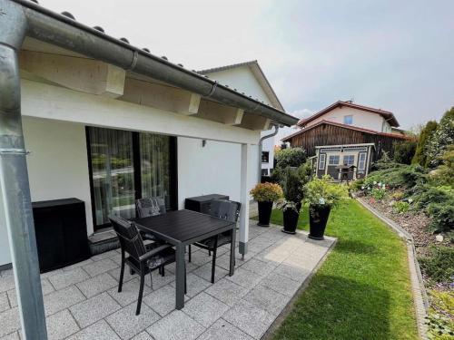 een patio met een zwarte tafel en stoelen naast een huis bij Ferienwohnung Helga in Schnaitsee