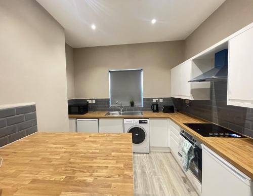 a kitchen with white cabinets and a washer and dryer at Spacious home near CityCentre Parking/Wifi/Netflix in Nottingham