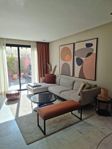 ein Wohnzimmer mit einem Sofa und einem Tisch in der Unterkunft Superbe appartement avec terrasse in Casablanca
