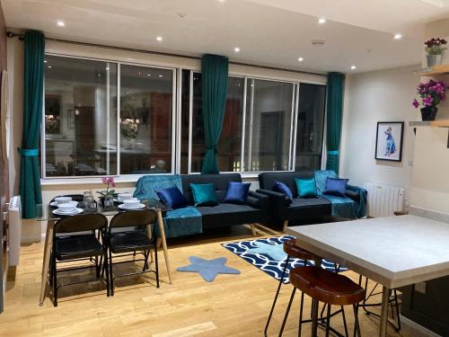a living room with a blue couch and a table at Central Sheffield 3BED 3BATH V Pent-Apartment in Sheffield