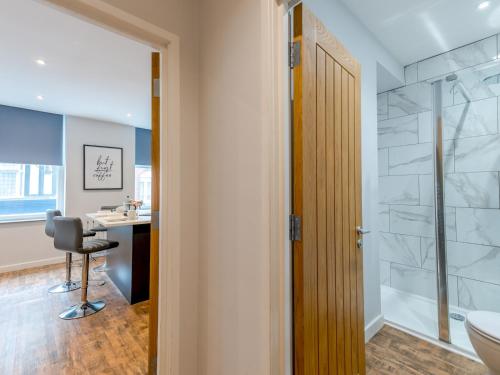 uma casa de banho com um chuveiro e uma secretária com uma cadeira. em Pass the Keys 5A One Bedroom Modern Town Centre Apartment em Shrewsbury