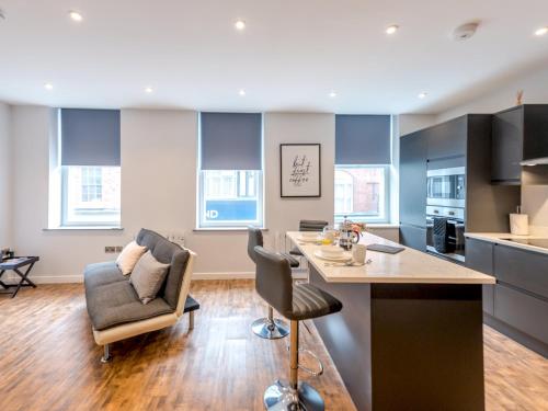 a kitchen and living room with a table and chairs at 5A One Bedroom Modern Town Centre Apartment - Pass the Keys in Shrewsbury
