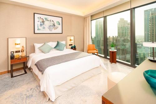 sypialnia z dużym łóżkiem i dużymi oknami w obiekcie Prime Retreats @ Address Residence Opera By Emaar w Dubaju