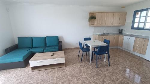 un soggiorno con divano, tavolo e sedie di Casa la Concha Costa Calma a Costa Calma