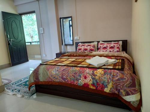 a bedroom with a large bed with pink pillows at Cardamom Blues in Aritar