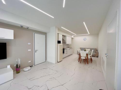 een witte woonkamer met een tafel en een keuken bij LA CASA DI ALICE in Pescantina