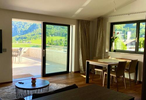 a living room with a table and a dining room with a view at Modern Living Sankt Gilgen in Sankt Gilgen