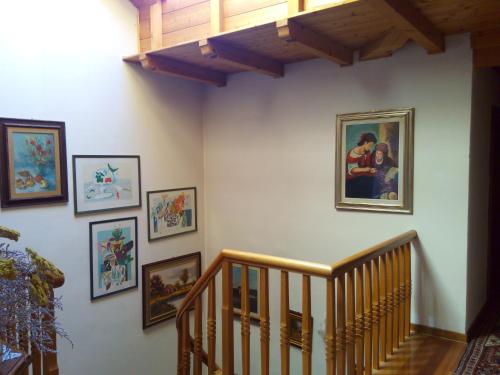 a hallway with pictures on the wall and a staircase at B&B Casa Bazzanella in Cavalese