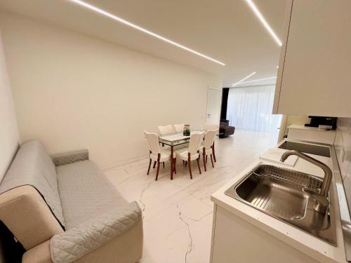 een keuken en een woonkamer met een bank en een tafel bij LA CASA DI ALICE in Pescantina