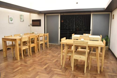 comedor con mesas y sillas de madera en CEJITAS HOSTEL en Córdoba