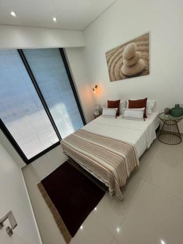 um quarto com uma cama grande e uma janela grande em Superbe Penthouse Terrasse avec vue Mer em Tel Aviv