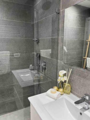 y baño con ducha acristalada y lavamanos. en Superbe Penthouse Terrasse avec vue Mer, en Tel Aviv