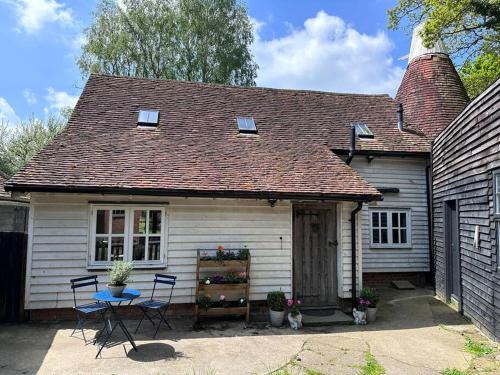 a small white house with a table and chairs at Beautiful 2 bed Oast - 15 acre farm - Tunbridge Wells in Royal Tunbridge Wells