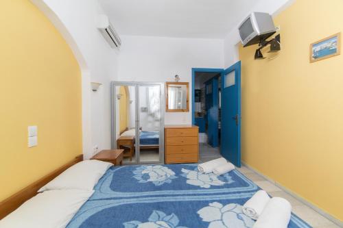 a bedroom with a bed and a tv on a wall at Astra Apartments in Agios Prokopios