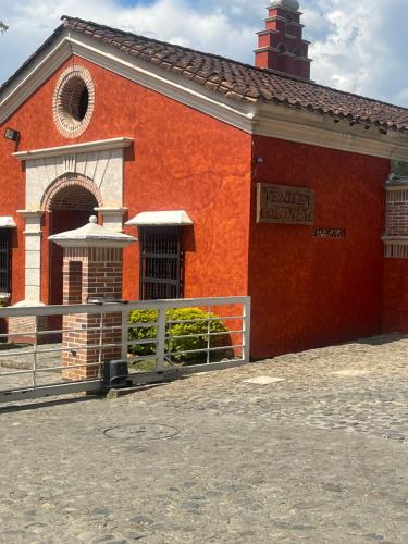 an orange building with a fence in front of it at Villa Venecia Colonial in Venecia