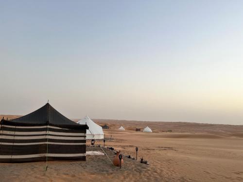 eine Gruppe von Zelten im Sand in der Wüste in der Unterkunft Starwatching Private Camp in Ḩawīyah