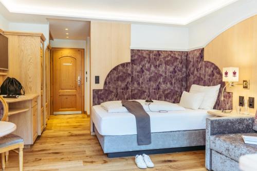 a hotel room with a bed and a bathroom at Hotel Neuhintertux 4 Sterne superior in Tux