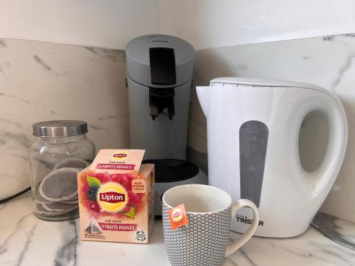 - une cafetière et une tasse de café sur un comptoir dans l'établissement Appartement T2 proche des prébendes, à Tours