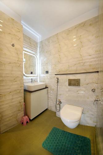 a bathroom with a white toilet and a sink at Friends Apartment Pvt.Ltd in Kathmandu